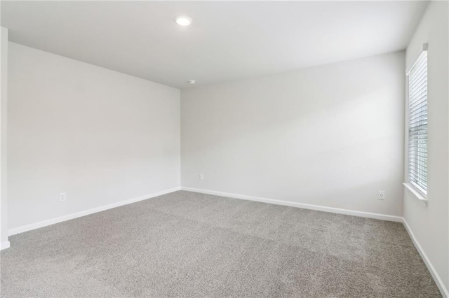 empty room featuring baseboards, carpet floors, and plenty of natural light