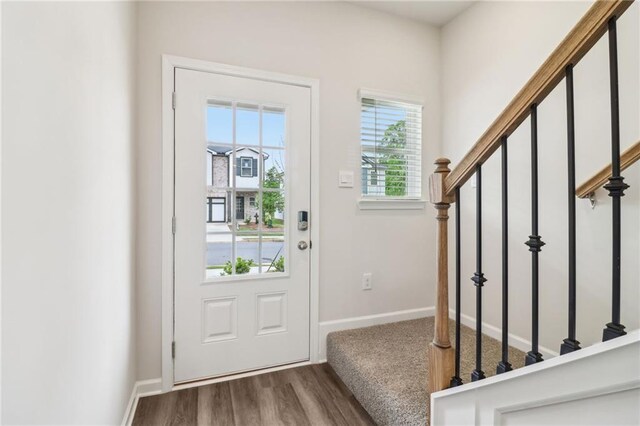entryway featuring baseboards, stairs, and wood finished floors