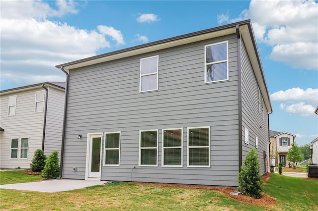 rear view of property featuring a yard, a patio area, and cooling unit