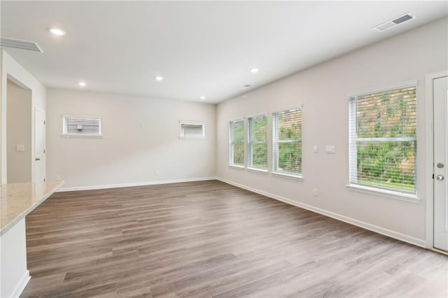 interior space featuring recessed lighting, baseboards, visible vents, and wood finished floors