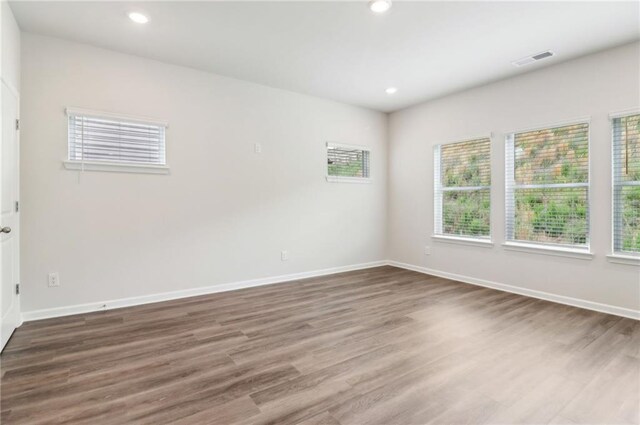 spare room with baseboards, recessed lighting, visible vents, and wood finished floors