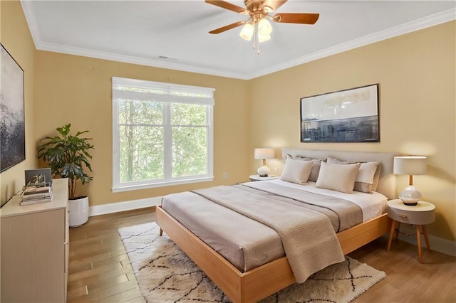 bedroom with ornamental molding, ceiling fan, and light hardwood / wood-style flooring