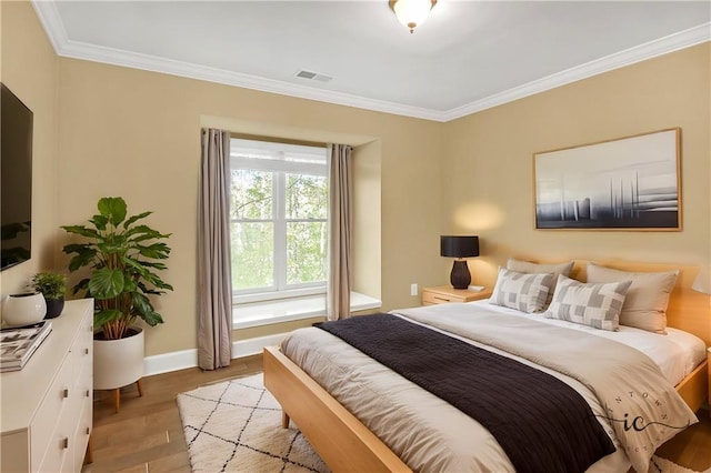 bedroom featuring light hardwood / wood-style flooring and ornamental molding