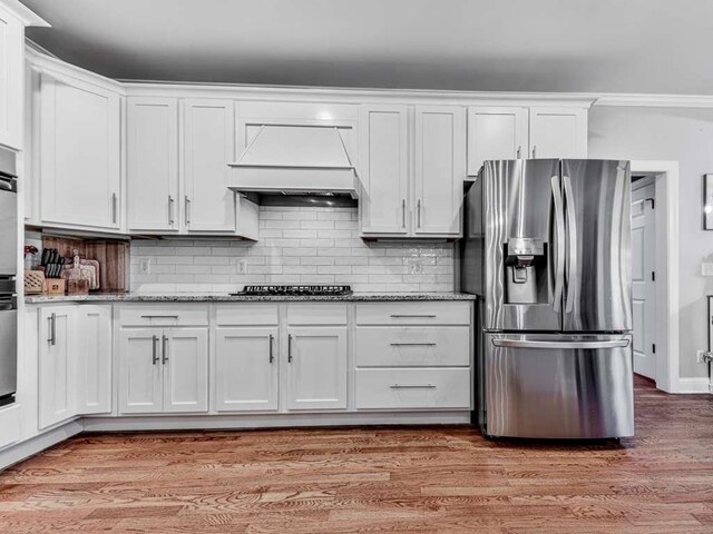 kitchen featuring black gas cooktop, white cabinetry, light hardwood / wood-style flooring, and stainless steel refrigerator with ice dispenser