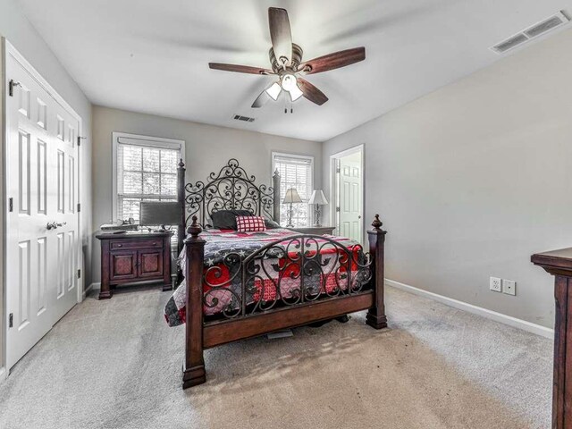 carpeted bedroom with ceiling fan and multiple windows