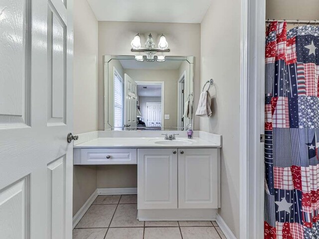 bathroom with tile patterned flooring, vanity, and walk in shower