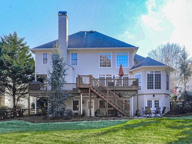 rear view of house with a wooden deck, a yard, and a patio