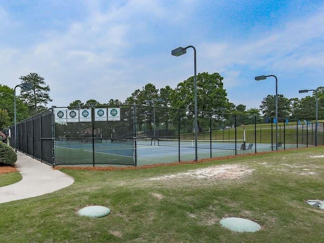 view of sport court with a lawn