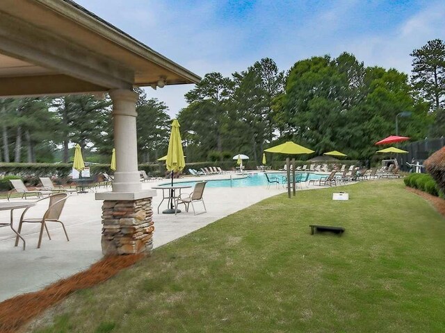 view of swimming pool with a yard and a patio