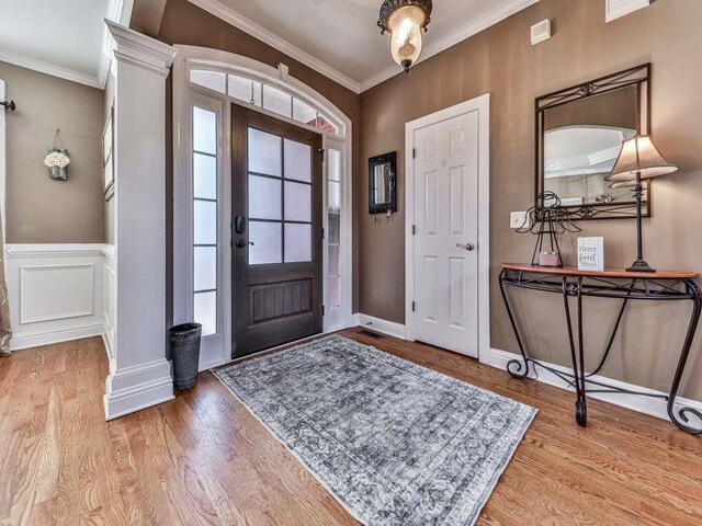 entryway featuring crown molding and light hardwood / wood-style flooring