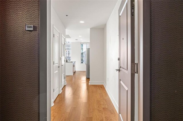 hallway featuring recessed lighting, light wood-type flooring, and baseboards