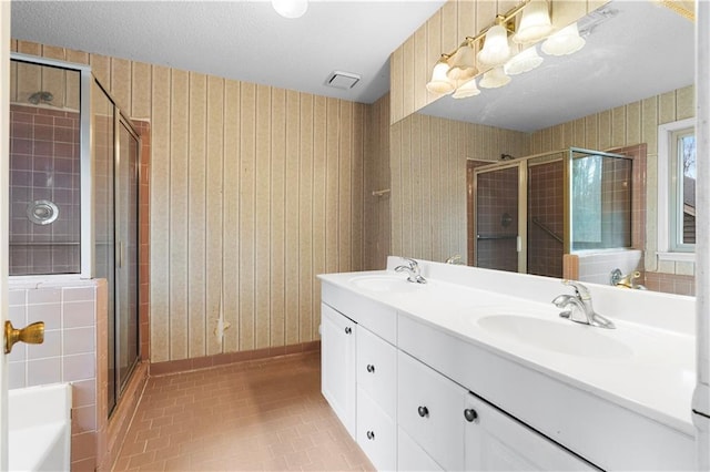 bathroom featuring tile patterned flooring, an enclosed shower, and vanity