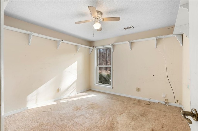 empty room with light carpet, ceiling fan, and a textured ceiling