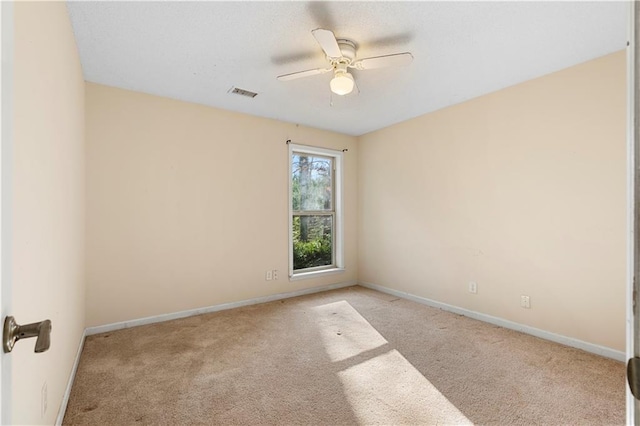 spare room featuring ceiling fan and light carpet