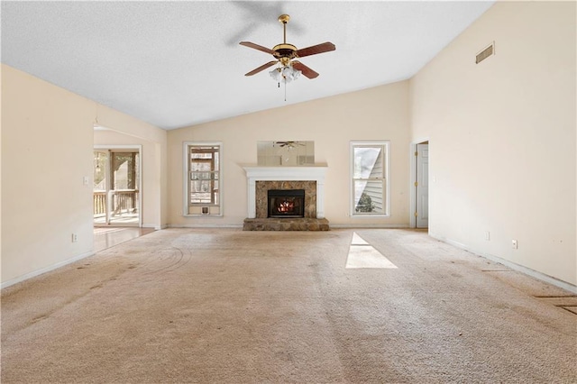 unfurnished living room with lofted ceiling, carpet floors, ceiling fan, and plenty of natural light