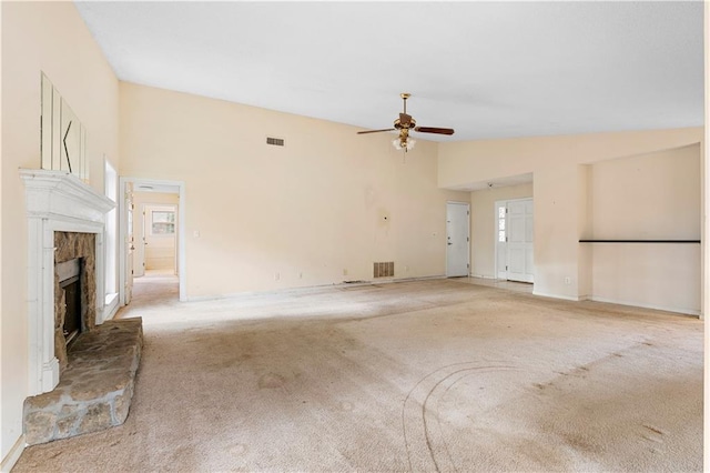 unfurnished living room with ceiling fan, light colored carpet, lofted ceiling, and a fireplace