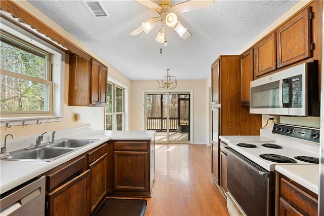 kitchen with kitchen peninsula, stainless steel appliances, a healthy amount of sunlight, and sink