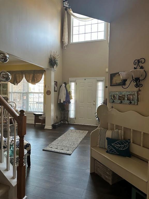 foyer with a high ceiling, stairway, and dark wood-style flooring