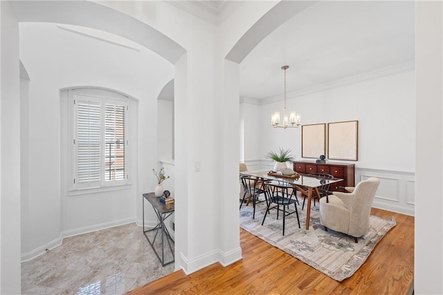 dining room featuring a chandelier, ornamental molding, and light wood-style flooring