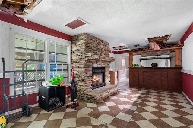 1550 Bells Ferry Rd, Marietta, GA 30066 - living area with a stone fireplace, tile patterned floors, a textured ceiling, and baseboards