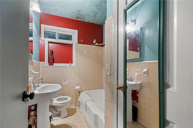 1550 Bells Ferry Rd, Marietta, GA 30066 - full bathroom featuring tile walls, tile patterned flooring, a tub to relax in, toilet, and wainscoting