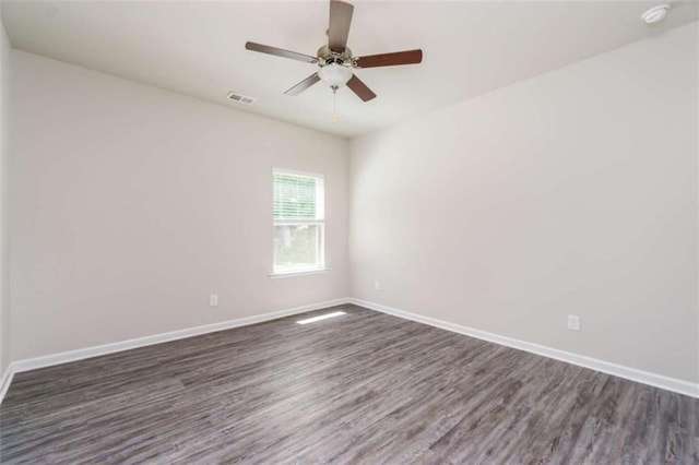 unfurnished room with dark wood-style flooring, baseboards, a ceiling fan, and a smoke detector