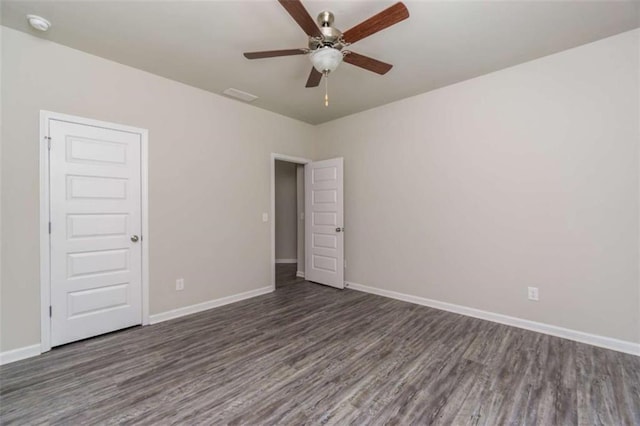 unfurnished room with wood finished floors, a ceiling fan, and baseboards