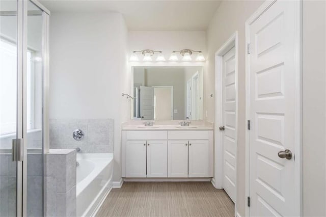 bathroom featuring a bath, double vanity, and an enclosed shower