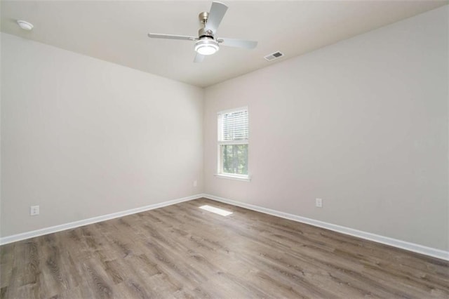 unfurnished room with wood finished floors, baseboards, ceiling fan, and a smoke detector