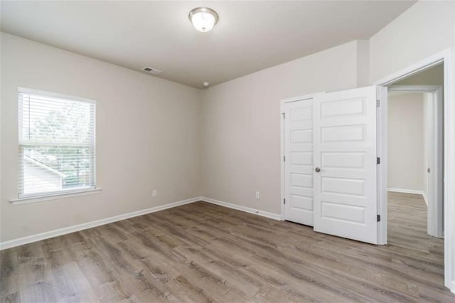 unfurnished bedroom featuring wood finished floors and baseboards