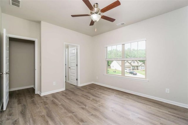 unfurnished bedroom with wood finished floors, baseboards, and ceiling fan