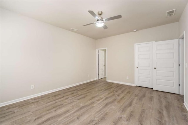 unfurnished bedroom with light wood-type flooring, baseboards, and ceiling fan