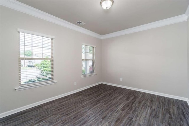 empty room featuring dark wood-style floors, crown molding, and baseboards