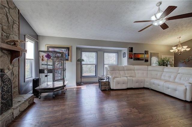 unfurnished living room featuring a healthy amount of sunlight, vaulted ceiling, dark wood-type flooring, and a fireplace