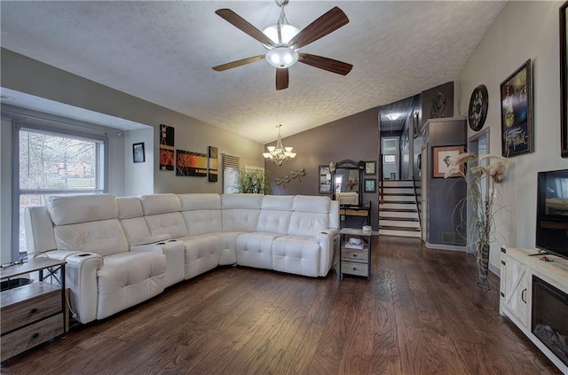 living room featuring ceiling fan with notable chandelier, dark hardwood / wood-style floors, a textured ceiling, and lofted ceiling