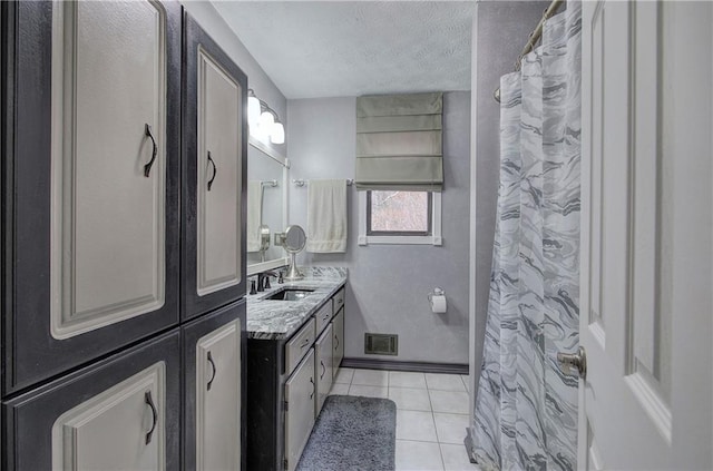 bathroom with tile patterned floors, vanity, and a textured ceiling