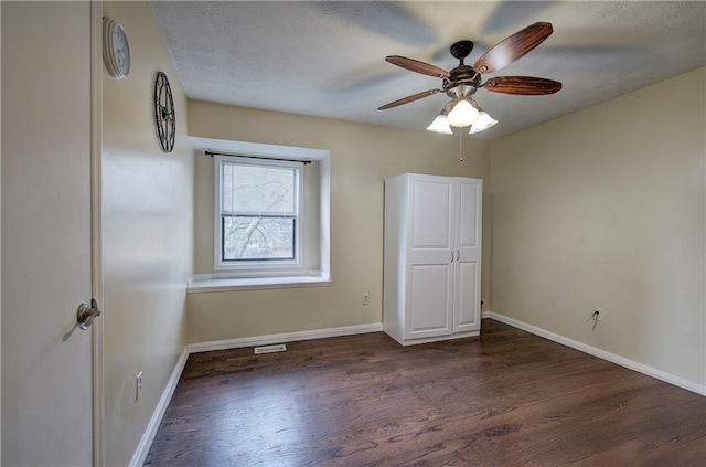 unfurnished bedroom featuring ceiling fan and dark hardwood / wood-style flooring