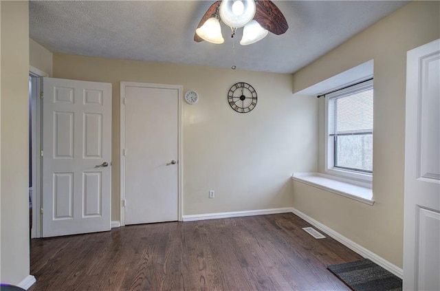 spare room with a textured ceiling, dark hardwood / wood-style floors, and ceiling fan