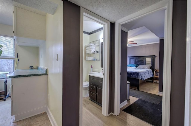 bathroom featuring hardwood / wood-style floors, vanity, a textured ceiling, ceiling fan, and toilet