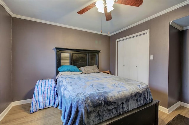 bedroom with hardwood / wood-style floors, ceiling fan, a closet, and crown molding