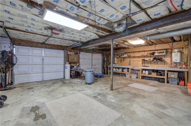 garage with a garage door opener, a workshop area, and water heater