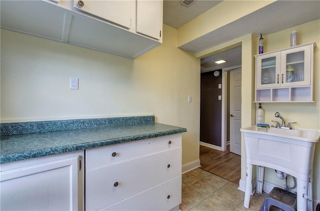 kitchen with light tile patterned floors and white cabinetry