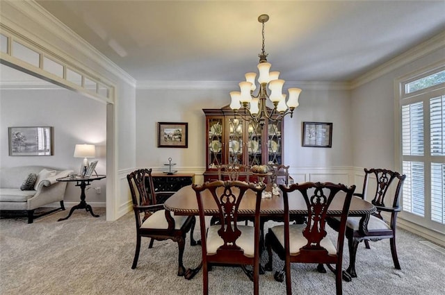 carpeted dining space with a notable chandelier, ornamental molding, and a healthy amount of sunlight