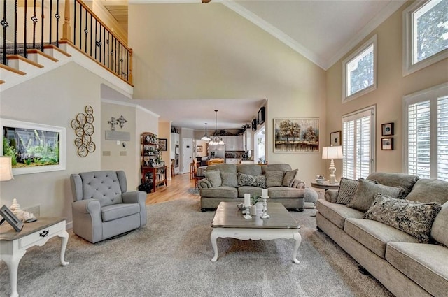 living room with hardwood / wood-style floors, a notable chandelier, crown molding, and high vaulted ceiling