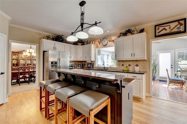 kitchen with white cabinetry, a center island, and a wealth of natural light