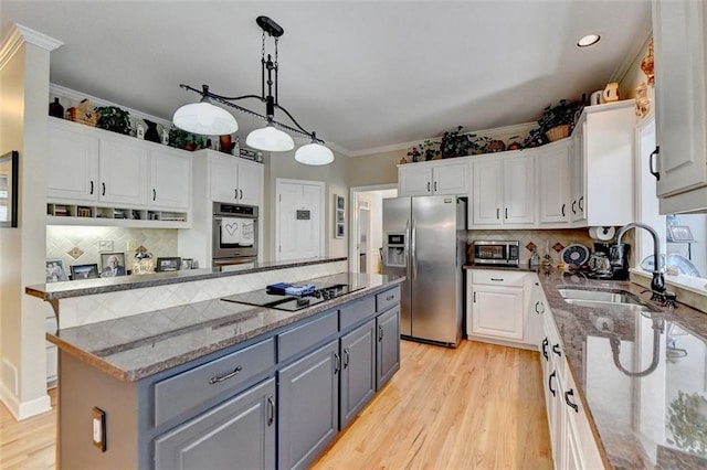 kitchen with white cabinetry, a center island, stainless steel fridge, and sink