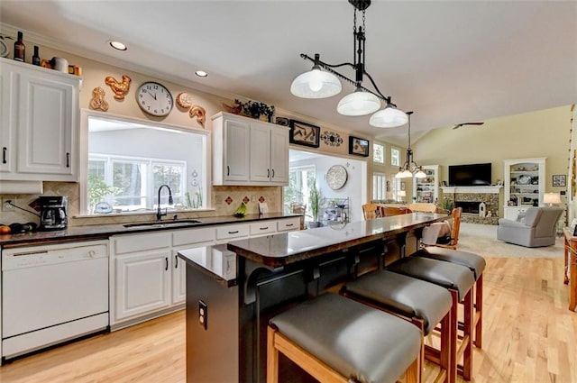 kitchen with white dishwasher, sink, and white cabinetry