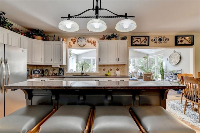 kitchen with stainless steel fridge, plenty of natural light, and a kitchen breakfast bar