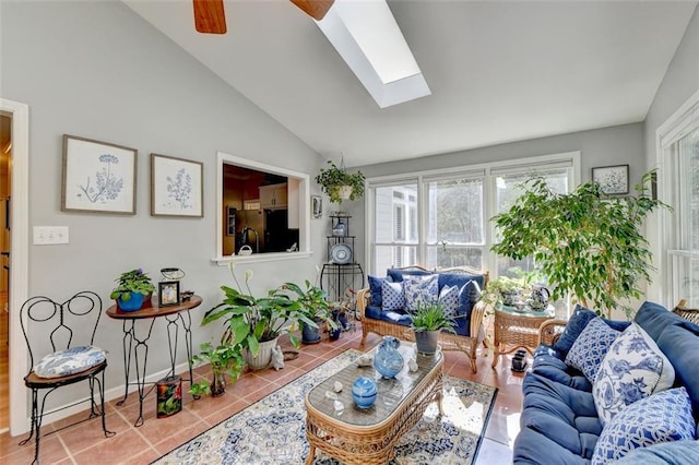 living room featuring lofted ceiling with skylight, tile patterned flooring, and ceiling fan