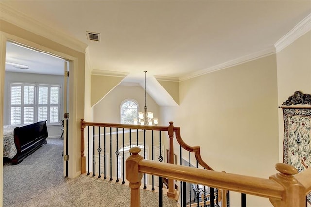 hallway featuring ornamental molding, a notable chandelier, and carpet floors